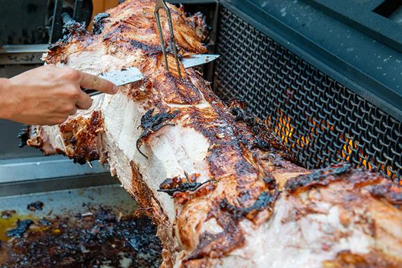 hog roast turning on bbq flames